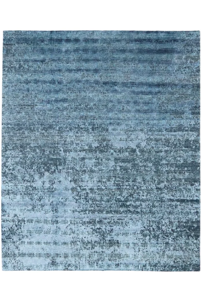 Der handgeknüpfte Teppich "Fresco Ocean" begeistert mit einem Design, das an den Meeresboden erinnert und in verschiedenen Blautönen gehalten ist. Sein edler Flor besteht aus feiner Seide und unsortierter Wolle und zeichnet sich durch eine besonders geringe Höhe aus. Hamburg, Middleway Gallery, Online Shop