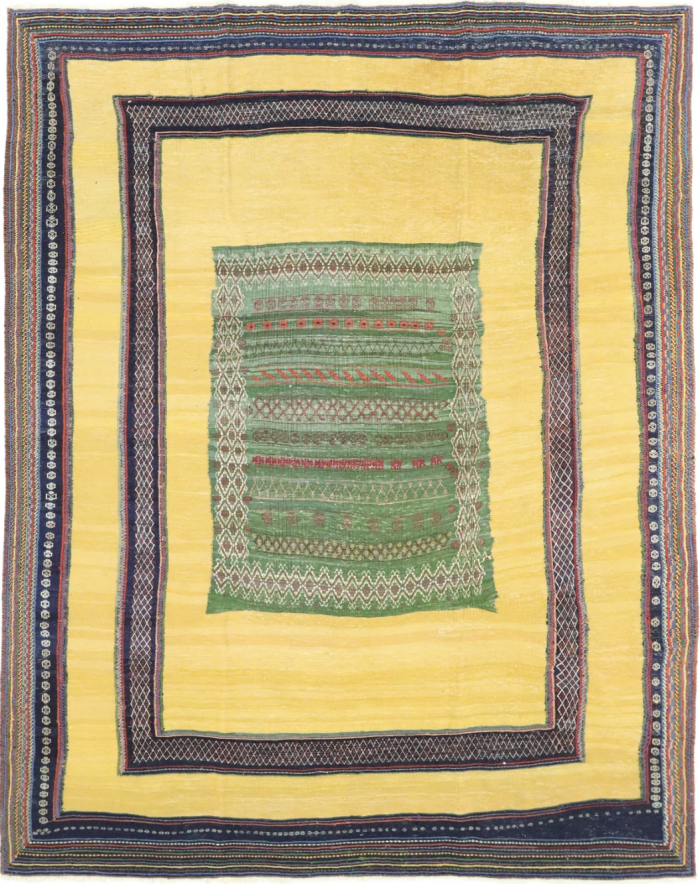 Nomadic, ein handgewebter Kelim, besticht durch seinen leuchtend gelben Grundton und ein Design, das mit verschiedenen Farben bestickt ist. Hamburg, Middleway Gallery, Online Shop