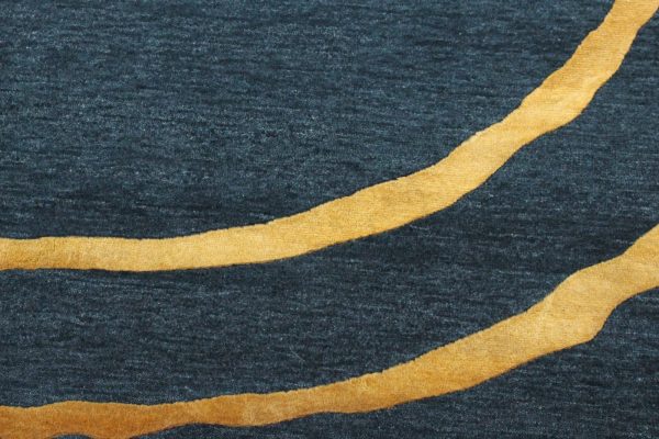 Entdecken Sie exquisite Handwerkskunst – der handgeknüpfte Teppich aus hochwertiger Wolle und edler Bambusseide. Das Circle-Design präsentiert sich in trendigem Petrol mit zwei goldenen Kreisen. Erhältlich im Onlineshop der Middleway Gallery in Hamburg