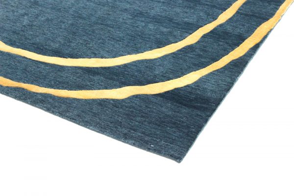 Entdecken Sie exquisite Handwerkskunst – der handgeknüpfte Teppich aus hochwertiger Wolle und edler Bambusseide. Das Circle-Design präsentiert sich in trendigem Petrol mit zwei goldenen Kreisen. Erhältlich im Onlineshop der Middleway Gallery in Hamburg
