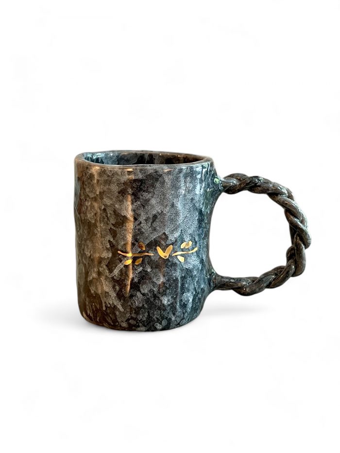 Handgefertigter Gisso Keramik Cup in milliertem Grau,dezent florales Design in Gold, zopfartiger handgeformter Henkel. Erhältlich im Hamburg Middleway Gallery und im Onlineshop.