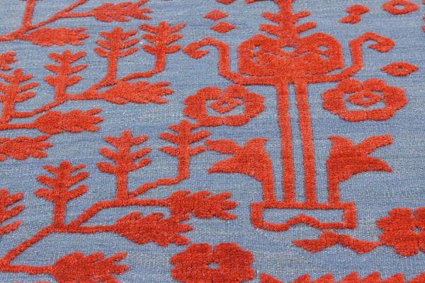 Handgewebter Zohra - Kelim mit erhabenen floralen Motiven in sattem Rot auf blauen Hintergrund.Erhältlich im Onlineshop de Middleway Gallery in Hamburg
